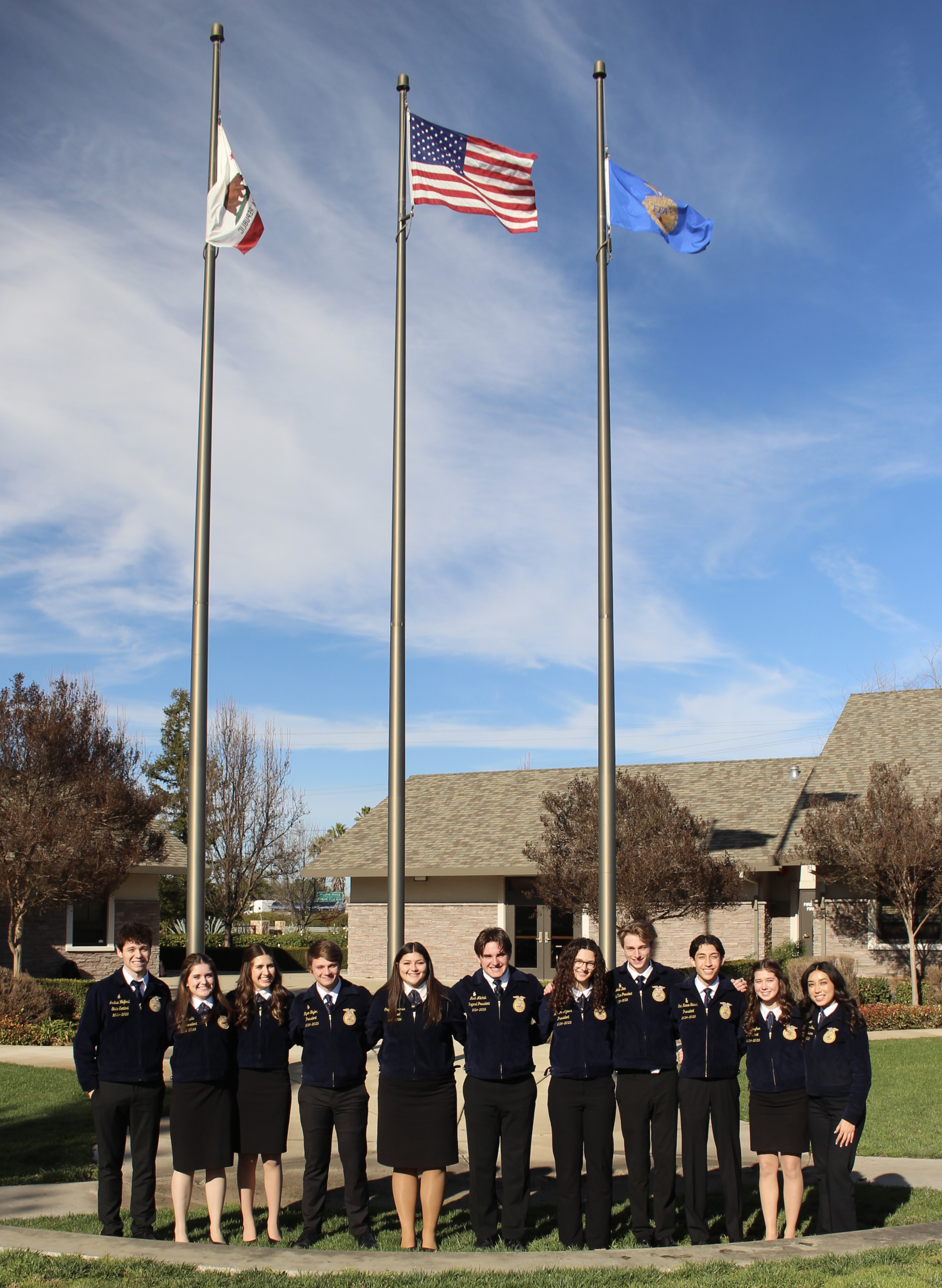 Executive committee standing in front of flags